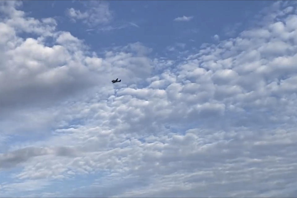 A small airplane circles over Tupelo, Miss., on Saturday, Sept. 3, 2022. Police say the pilot of the small airplane is threatening to crash the aircraft into a Walmart store. The Tupelo Police Department said that the Walmart and a nearby convenience store had been evacuated. (Rachel McWilliams via AP)