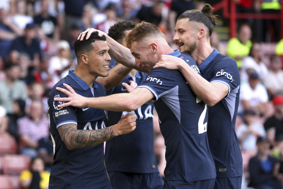 Tottenham Hotspur's Pedro Porro, left, celebrates scoring their side's second goal of the game with team-mates during the Premier League match between Sheffield and Tottenham Hotspur at Bramall Lane, Sheffield., Sunday May 19, 2024. (Barrington Coombs/PA via AP)