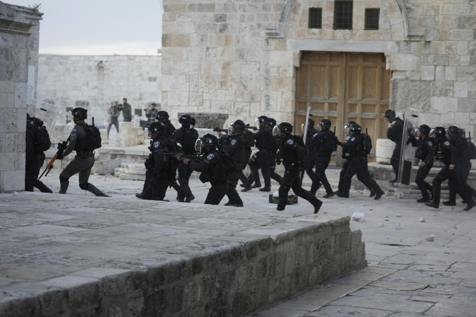 Israeli police enter the Al Aqsa Mosque compound where they clashed with Palestinian protesters following early morning prayers in Jerusalem's Old City, Friday, April 22, 2022. Israeli police and Palestinian youths clashed again at the major Jerusalem holy site sacred to Jews and Muslims on Friday despite a temporary halt to Jewish visits to the site, which are seen as a provocation by the Palestinians. (AP Photo/Mahmoud Illean)