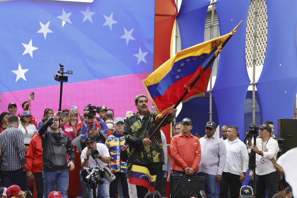 Venezuela's President Nicolas Maduro waves his country's national flag during an event marking the anniversary of the 1958 coup that overthrew dictator Marcos Perez Jimenez, in Caracas, Venezuela, Tuesday, Jan. 23, 2024. (AP Photo/Jesus Vargas)