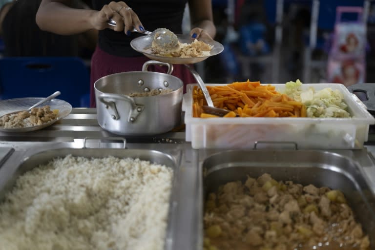 Una profesora se sirve el almuerzo en el comedor de la escuela Burle Marx, en Rio de Janeiro, el 4 de abril de 2024 (Pablo PORCIUNCULA)