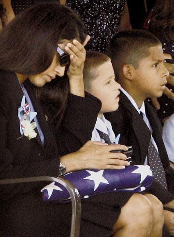 Oct. , 2006: Denise Locklear sits with sons Nathan, 5, and Velton IV, as she holds the Bronze Star, Purple Heart and casket flag given to her during her husband's funeral at Fort Bliss National Cemetery.