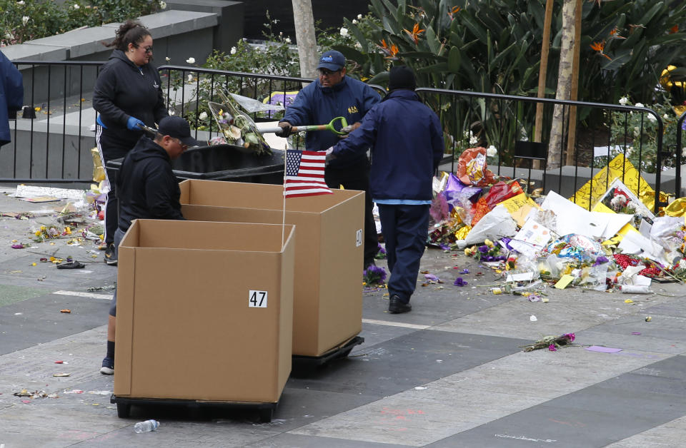 Workers remove thousands of items left in honor of Kobe Bryant, including hundreds of basketballs, from X-Box Plaza across Chick Hearn Court from Staples Center, home of the Los Angeles Lakers, early Monday, Feb. 3, 2020, in Los Angeles. Mourners left the items after the death of the former Lakers legend, his daughter and seven others, in a helicopter crash one week ago. (AP Photo/Reed Saxon)