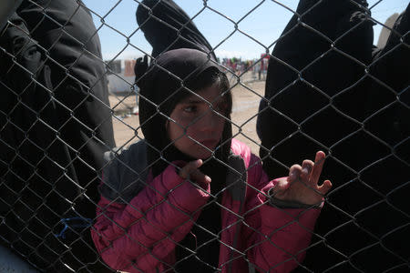 A girl looks through a chain linked fence at al-Hol displacement camp in Hasaka governorate, Syria March 8, 2019. REUTERS/Issam Abdallah