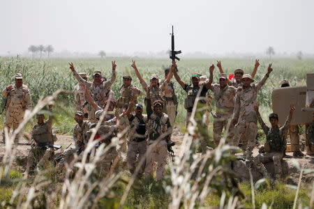 Members of Iraqi security forces gesture near Falluja, Iraq, May 25, 2016. REUTERS/Thaier Al-Sudani