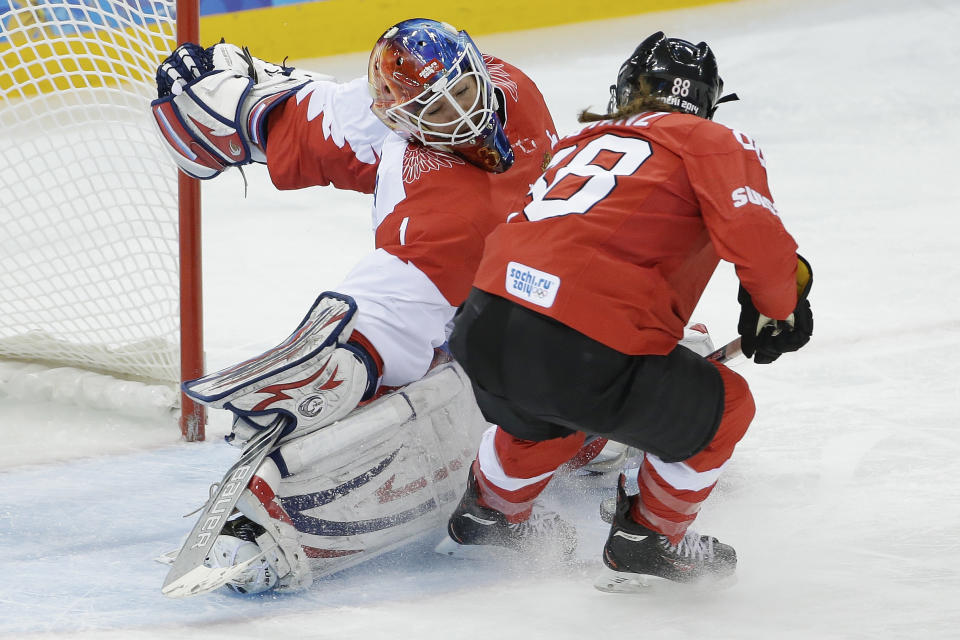 Goalkeeper Anna Prugova of Russia blocks a shot at the goal by Phoebe Stanz of Switzerland during the 2014 Winter Olympics women's ice hockey quarterfinal game at Shayba Arena, Saturday, Feb. 15, 2014, in Sochi, Russia. (AP Photo/Matt Slocum)