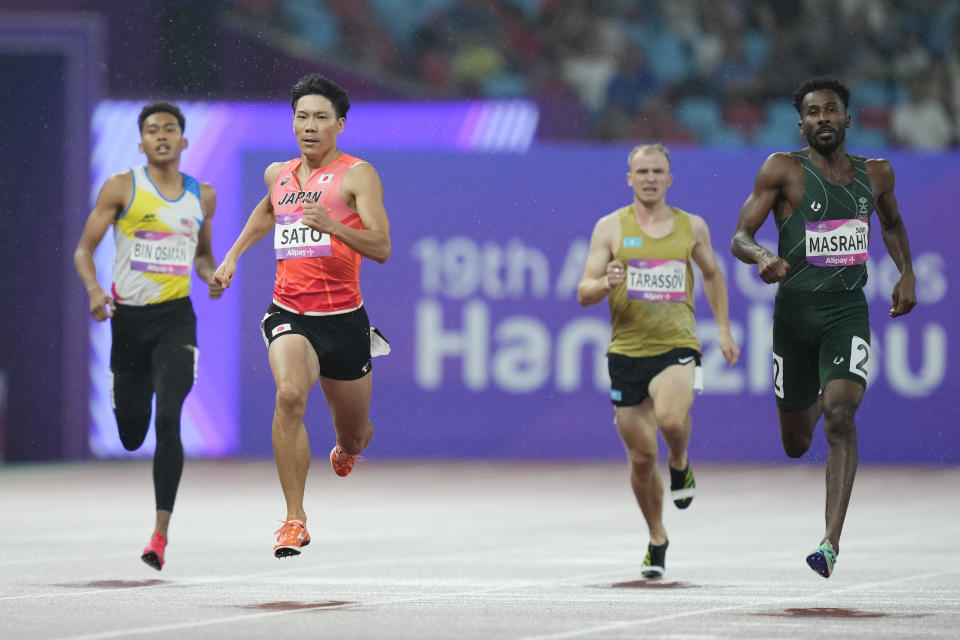 CORRECTS TO SATO BEING SECOND FROM LEFT AND SPELLING OF YOUSEF AND NOT YOUTH AS ORIGINALLY SENT - Japan’s Fuga Sato, second left, and Saudi Arabia’s Yousef Ahmed Masrahi, right, compete during the men's 400m heat at the 19th Asian Games in Hangzhou, China, Friday, Sept. 29, 2023. (AP Photo/Vincent Thian)