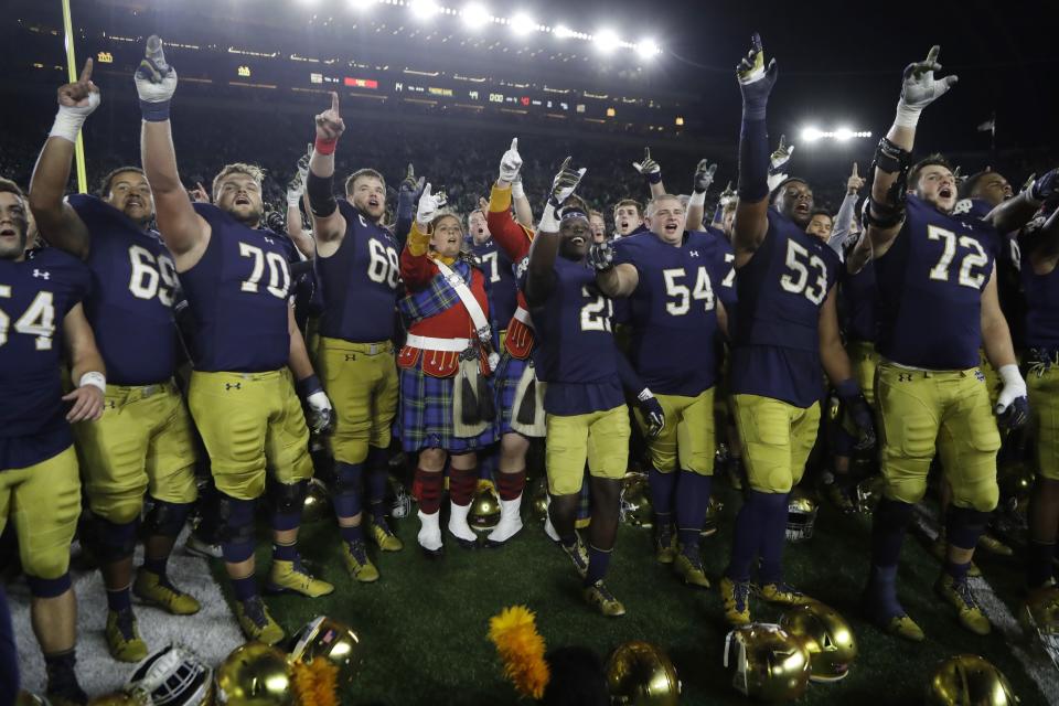 Notre Dame team members sing with students after routing USC on Saturday, 49-14. (AP)