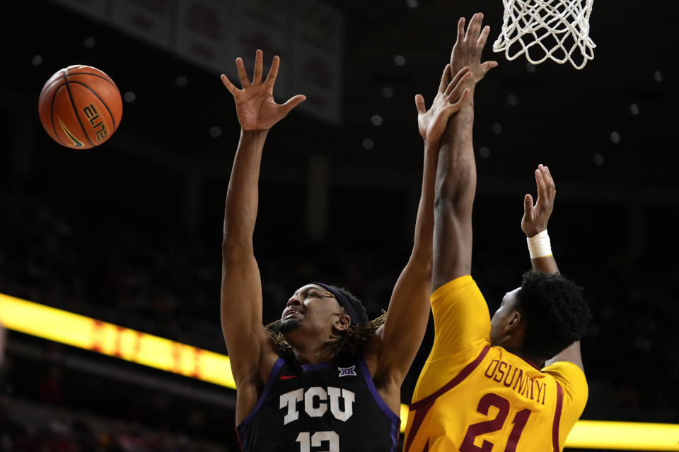 TCU forward Xavier Cork, left, fights for a rebound with Iowa State center Osun Osunniyi during the second half of an NCAA college basketball game, Wednesday, Feb. 15, 2023, in Ames, Iowa. (AP Photo/Charlie Neibergall)