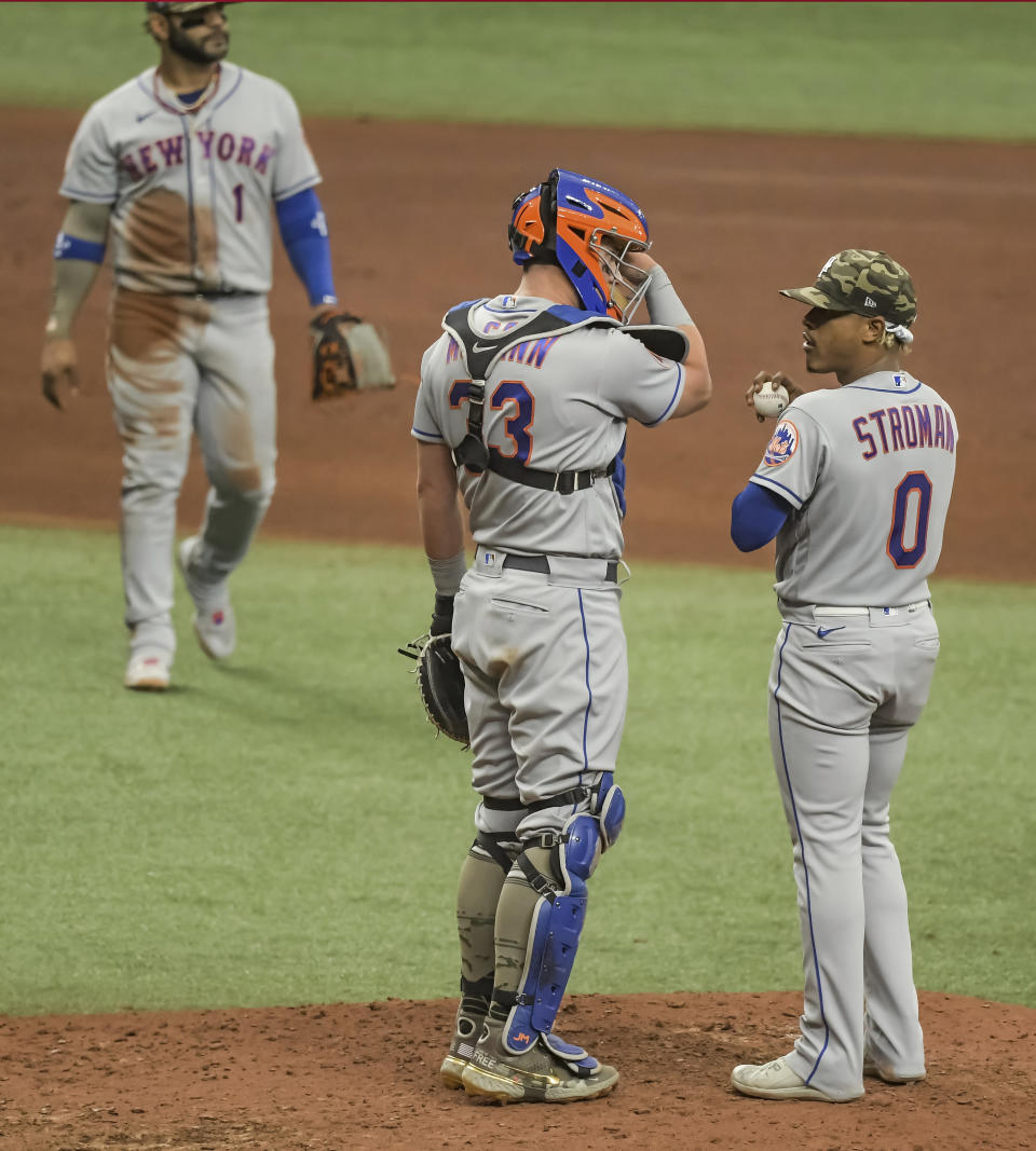 New York Mets catcher James McCann (33) talks with Marcus Stroman (0) after giving up a two-run home run to Tampa Bay Rays' Willy Adames during the fifth inning of a baseball game Sunday, May 16, 2021, in St. Petersburg, Fla. (AP Photo/Steve Nesius)