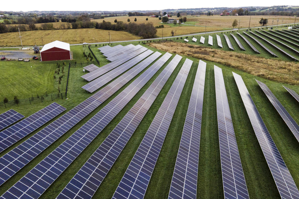 FILE - Farmland is seen with solar panels from Cypress Creek Renewables, Oct. 28, 2021, in Thurmont, Md. President Joe Biden plans to invoke the Defense Production Act to increase U.S. manufacturing of solar panels while declaring a two-year tariff exemption on panels from Southeast Asia. (AP Photo/Julio Cortez, File)