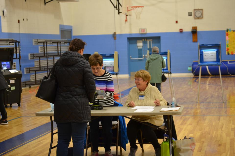 Precinct clerks check in a voter at Gaudet Middle School in Middletown on Tuesday, Nov. 7.
