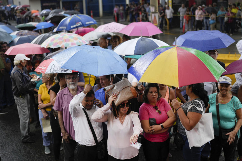 FILE - People line up to vote in the opposition primary election that was later denounced as illegal by the government, in Caracas, Venezuela, on a rainy Oct. 22, 2023. Organized by the National Primary Commission, the election drew more than 2.4 million voters in Venezuela and abroad and was aimed at choosing a candidate to run against President Nicolás Maduro. (AP Photo/Matias Delacroix, File)