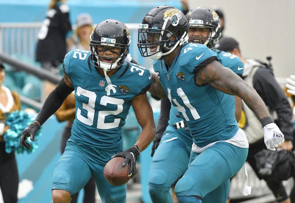 Jacksonville Jaguars cornerback Tyson Campbell (32) celebrates with outside linebacker Josh Allen (41) and other teammates after he intercepted a pass intended for Houston Texans tight end Jordan Akins (88) during fourth quarter action. The Jacksonville Jaguars hosted the Houston Texans at TIAA Bank Field in Jacksonville, Florida Sunday, December 19, 2021. The Jaguars fell to the Texans with a final score of 30 to 16. [Bob Self/Florida Times-Union]