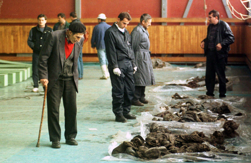 FILE - In this Oct. 9, 1996. file photo, Bosnian Muslims trying to recognize their relatives killed by Bosnian Serbs in 1992, inside a sport hall in Kljuc, 160 kms (100mls) north-west of Sarajevo, Bosnia. While it brought an end to the fighting, the Dayton peace agreement baked in the ethnic divisions, establishing a complicated and fragmented state structure with two semi-autonomous entities, Serb-run Republika Srpska and a Federation shared by Bosniak and Croats, linked by weak joint institutions. (AP Photo/Darko Bandic, File)