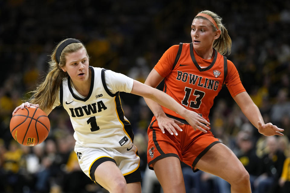 Iowa guard Molly Davis (1) drives past Bowling Green forward Olivia Hill (13) during the first half of an NCAA college basketball game, Saturday, Dec. 2, 2023, in Iowa City, Iowa. (AP Photo/Charlie Neibergall)