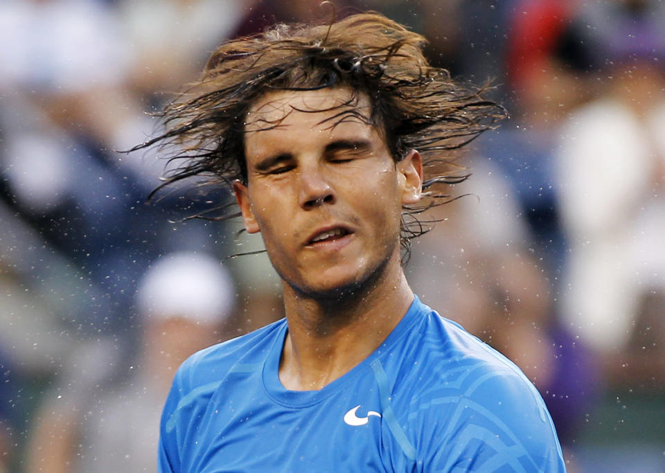 Rafael Nadal of Spain shakes the sweat off his hair after defeating compatriot Marcel Granollers in their match at the Indian Wells ATP tennis tournament in Indian Wells, California, March 13, 2012. REUTERS/Danny Moloshok (UNITED STATES - Tags: SPORT TENNIS TPX IMAGES OF THE DAY)