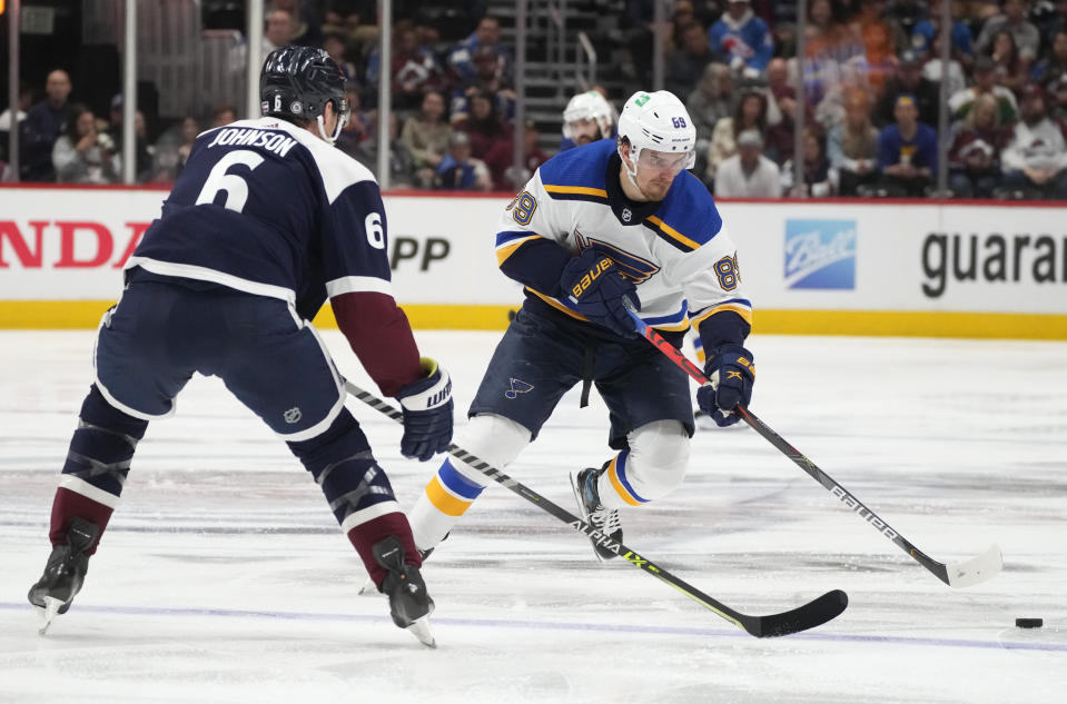 St. Louis Blues left wing Pavel Buchnevich, right, drives to the net as Colorado Avalanche defenseman Erik Johnson covers in the second period of an NHL hockey game Tuesday, April 26, 2022, in Denver. (AP Photo/David Zalubowski)