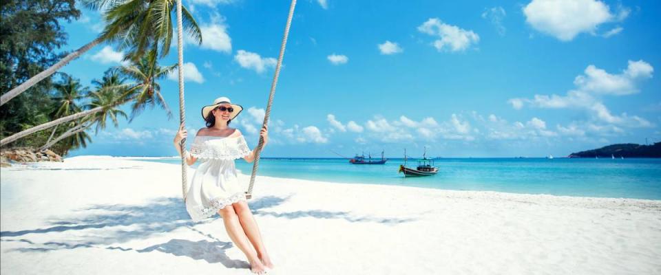 Beautiful woman swinging on a Tropical beach on affordable Koh Phangan island. Thailand, Asia
