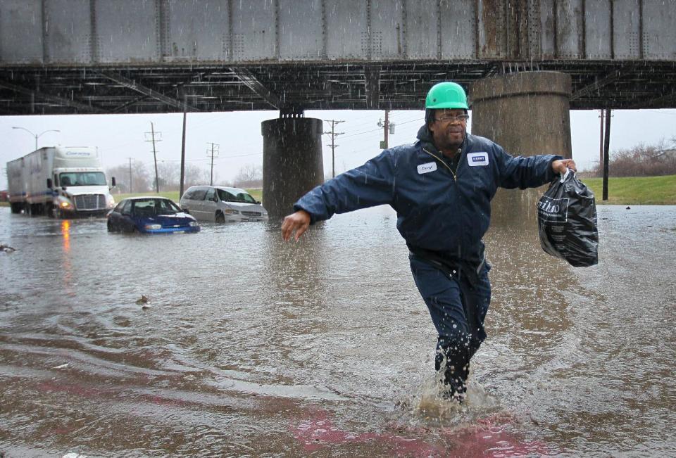 Darryl Hamilton walks away from his minivan stuck in floodwater in St. Louis on Wednesday, April 2, 2014. Three vehicles became stuck in the high water caused by a downpour. Everyone in the vehicles was able to walk out of the water on their own or were helped by police to dry land. (AP Photo/St. Louis Post-Dispatch, David Carson) (AP Photo/St. Louis Post-Dispatch, ) EDWARDSVILLE INTELLIGENCER OUT; THE ALTON TELEGRAPH OUT.