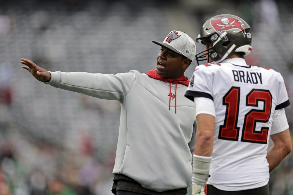 Tampa Bay Buccaneers offensive coordinator Byron Leftwich talks to Tom Brady on the field before an NFL football game against the New York Jets, Sunday, Jan. 2, 2022, in East Rutherford, N.J. (AP Photo/Adam Hunger)