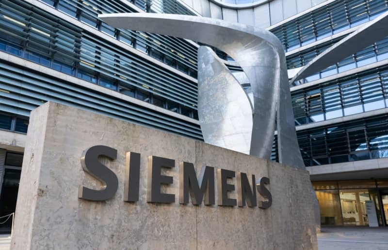 Siemens logo can be seen in front of the company headquarters. Sven Hoppe/dpa