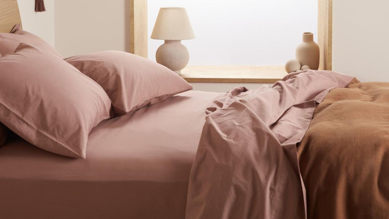 a bed with a pink comforter
