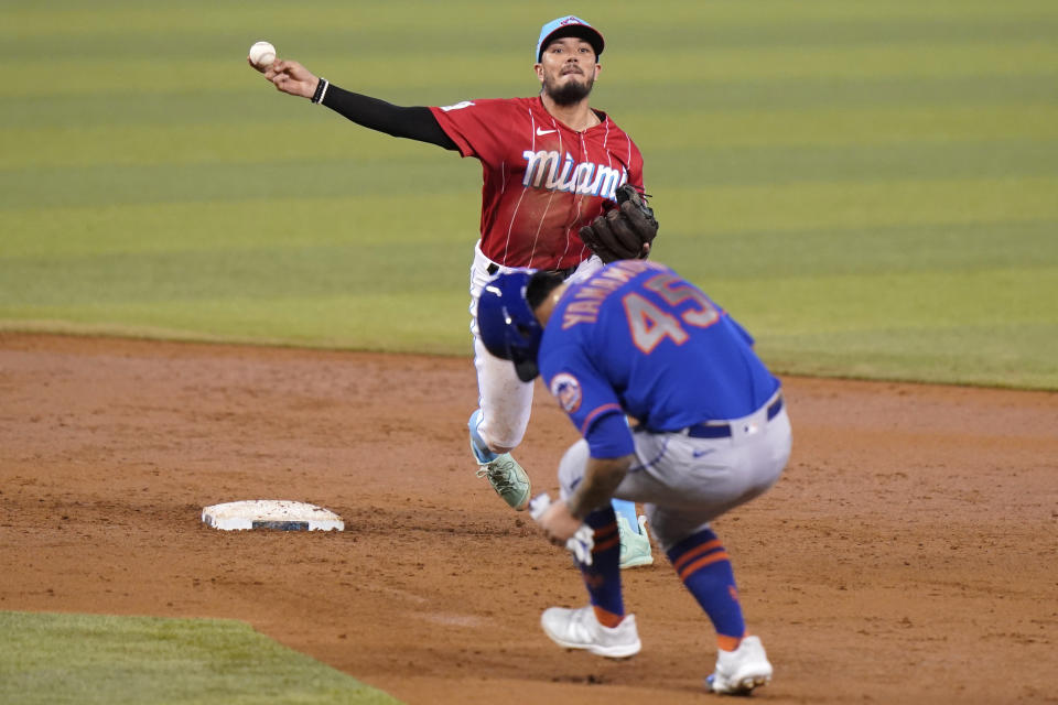 New York Mets' Jordan Yamamoto, right, is out at second as Miami Marlins shortstop Miguel Rojas, left, throws to first for a double play during the third inning of a baseball game, Sunday, May 23, 2021, in Miami. (AP Photo/Lynne Sladky)
