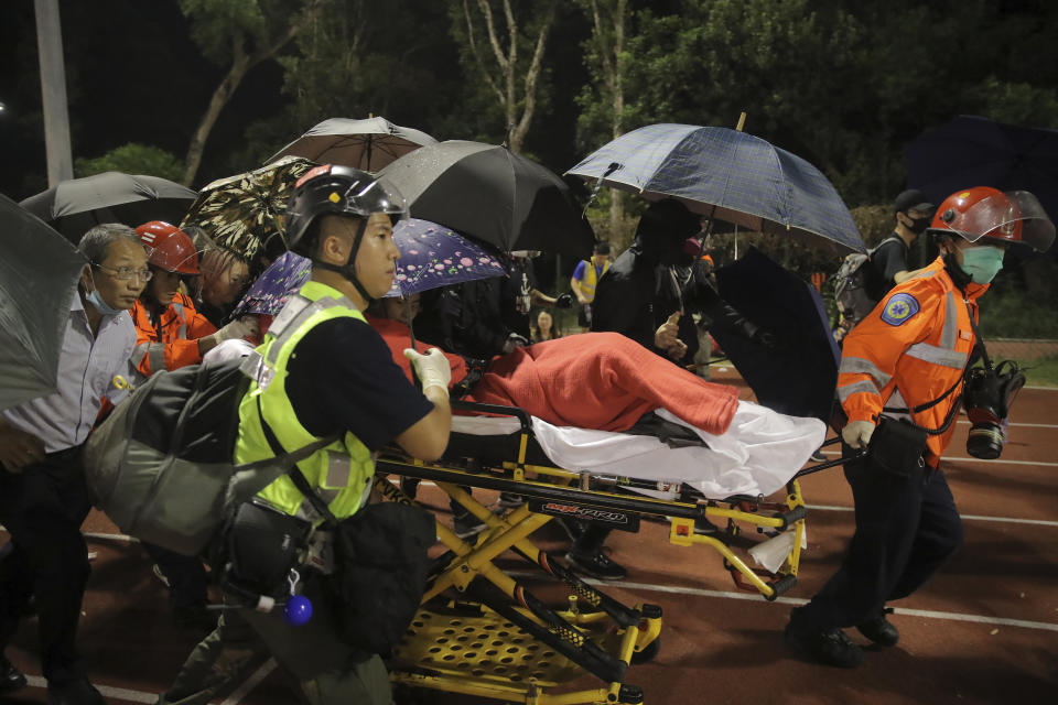 Medical workers move an injured student following clashes with police at the Chinese University in Hong Kong, Tuesday, Nov. 12, 2019. Police and protesters battled outside university campuses and several thousand demonstrators blocked roads as they took over a central business district at lunchtime on Tuesday in another day of protest in Hong Kong. (AP Photo/Kin Cheung)