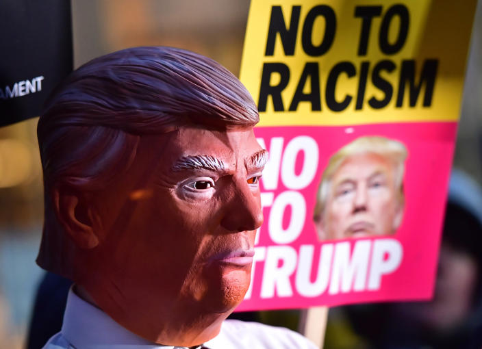 <p>A campaigner with a Donald Trump mask outside the American Embassy in London protesting against new US President Donald Trump. (Dominic Lipinski/PA Images via Getty Images) </p>