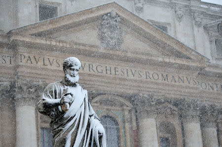 The statue of Saint Peter is pictured during a heavy snowfall in Saint Peter's Square at the Vatican. REUTERS/Max Rossi