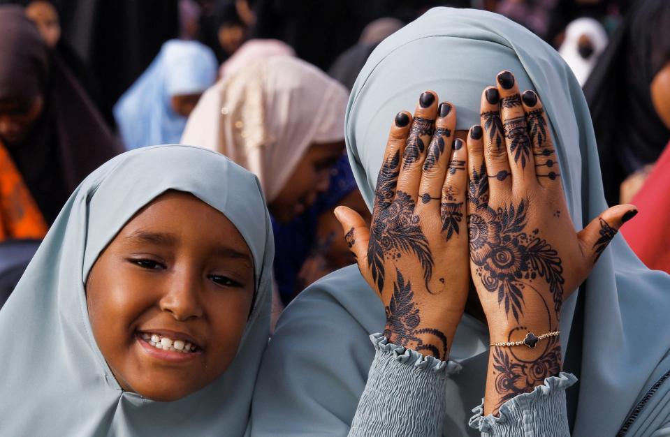 A Muslim faithful displays her henna decoration before attending Eid al-Fitr prayers at the Masjid Salaam grounds in Nairobi, Kenya (REUTERS/Monicah Mwangi)