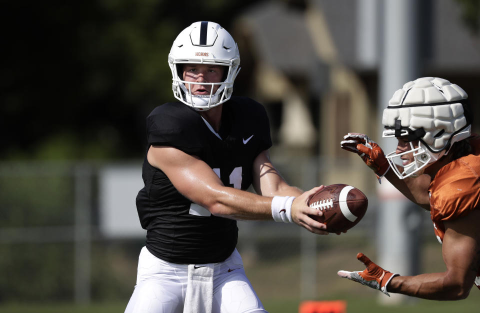 Texas quarterback Sam Ehlinger, left, and running back Jordan Whittington, right, take part in a morning practice at the team's facility in Austin, Texas, Wednesday, Aug. 7, 2019. (AP Photo/Eric Gay)