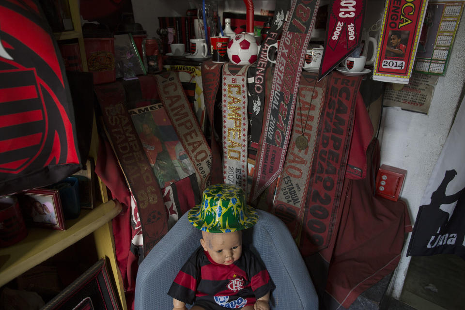 In this April 28, 2014 photo, Flamengo soccer team souvenirs decorate the home of Maria Boreth de Souza, alias Zica, in the Olaria neighborhood of Rio de Janeiro, Brazil. Souza's small concrete house is painted in Flamengo team colors, red and black. Her living room and sleeping quarters are bedecked with Flamengo jerseys, banners, beer mugs and other team memorabilia. Even a curtain in front of her kitchen is a plastic Flamengo flag. (AP Photo/Leo Correa)