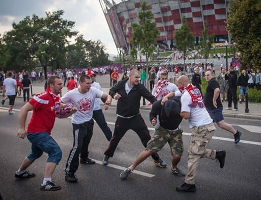 Polish football fans beat a Russian football fan during clashes in Warsaw. Police used an arsenal of tear gas, water cannon, rubber bullets and pepper spray and detained dozens of brawling football fans ahead of a key Euro 2012 match between Poland and Russia on Tuesday