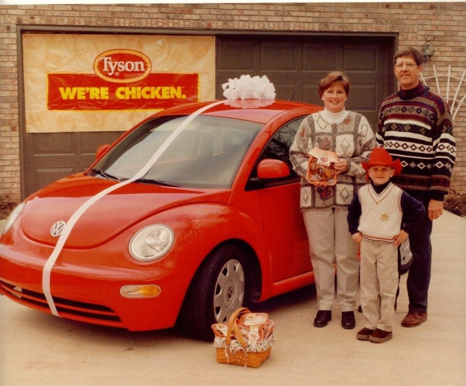 Julianne Fridley poses in January 1999 with her late husband, Gary Fridley, and their son, next to the 1998 Volkswagen Beetle they won in a chicken sweepstakes.