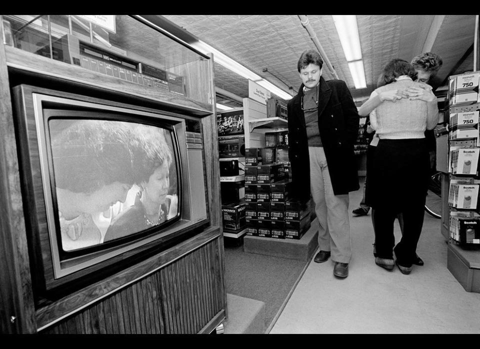 Customer David Kimball reacts as store employees Lynne Beck and Lisa Olson embrace. They watched the Houston memorial service for the astronauts who died in the Challenger explosion at a store in Concord, N.H. Pictured on the television screen are family members of one of the astronauts. AP/Charles Krupa/1986 (<a href="http://www.boston.com/bigpicture/2011/01/challenger_disaster_25_years_l.html" target="_hplink">Via the Big Picture</a>)