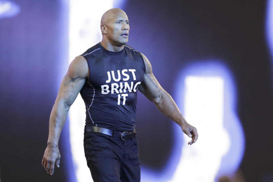 FILE - Dwayne "The Rock" Johnson makes his entrance at Wrestlemania XXXI, Sunday, March 29, 2015, in Santa Clara, Calif. Dwayne “The Rock” Johnson is back to perform in one of the main events this weekend's WrestleMania in Philadelphia. (Don Feria/AP Images for WWE, File)