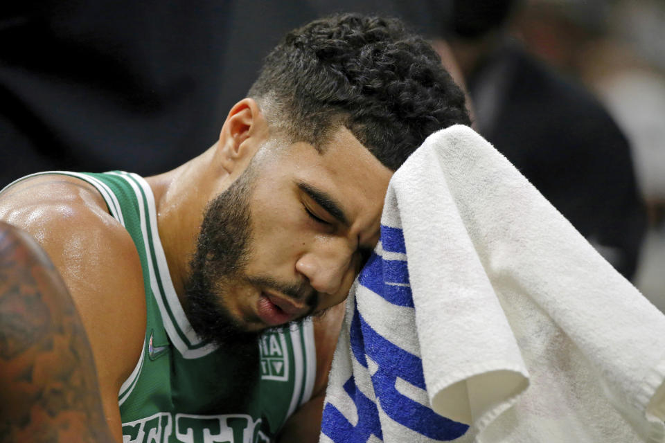 Boston Celtics forward Jayson Tatum wipes off his forehead during a timeout in the first half of the team's NBA basketball game against the Milwaukee Bucks on Saturday, Dec. 25, 2021, in Milwaukee. (AP Photo/Jon Durr)
