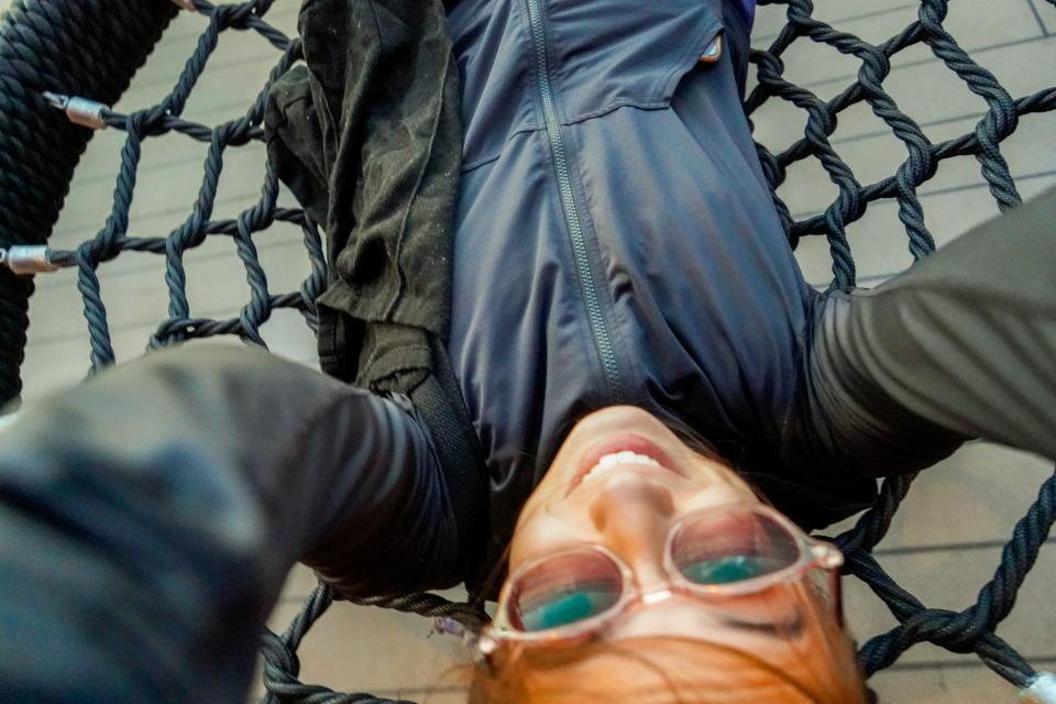 An aerial view of the author on a netted swing smiling.