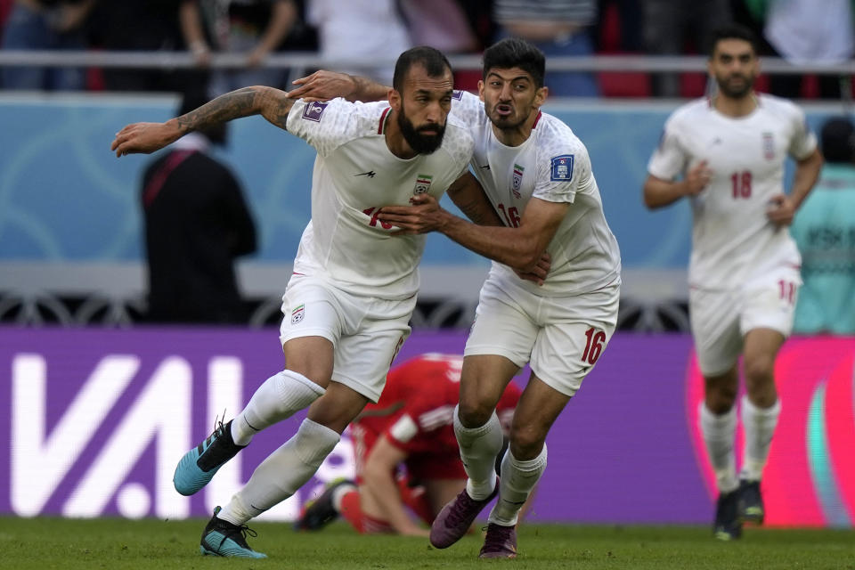 Iran's Rouzbeh Cheshmi, left, and Iran's Mehdi Torabi celebrate after scoring their side's first goal during the World Cup group B soccer match between Wales and Iran, at the Ahmad Bin Ali Stadium in Al Rayyan , Qatar, Friday, Nov. 25, 2022. (AP Photo/Frank Augstein)