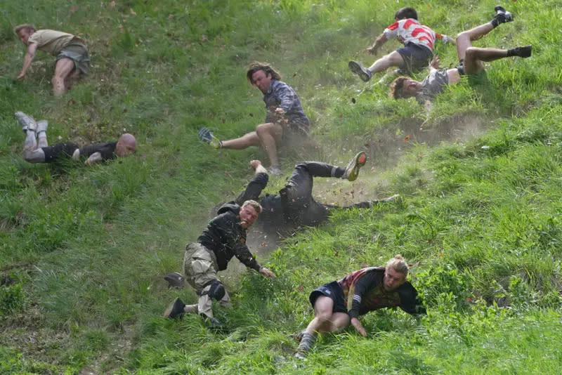 ▲英國一年一度的「滾起司大賽（Cheese Rolling Race）」日前在格洛斯特（Gloucester）附近的庫柏山（Cooper's Hill）登場，參賽者從陡坡上追逐往下滾的起司，誰先抓到起司或是誰最新衝到坡底就是贏家。資料照。（圖／美聯社／達志影像）