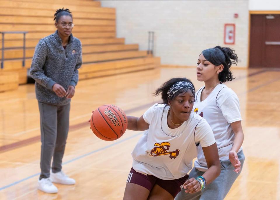 West High basketball coach Brittanie Brickhouse watches members of her team practice recently. The team had to forfeit the remaining games on their schedule due to often not having enough players. Despite having no games to play, the remaining girls still come to practice every day.