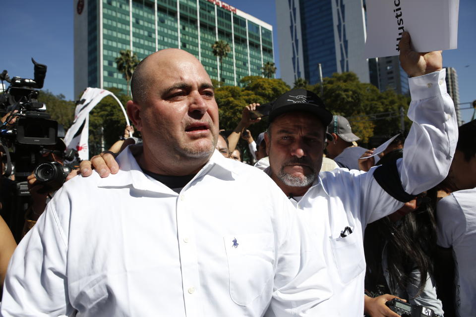 Julian LeBaron, left, walks with Adrian LeBaron before a protest against the first year in office of Mexico's President Andres Manuel Lopez Obrador, in Mexico City, Sunday, Dec. 1, 2019. The men joined a protest on Mexico City's Reforma avenue to expressed anger and frustration over increasingly appalling incidents of violence, a stagnant economy and deepening political divisions in the country. (AP Photo/Ginnette Riquelme)
