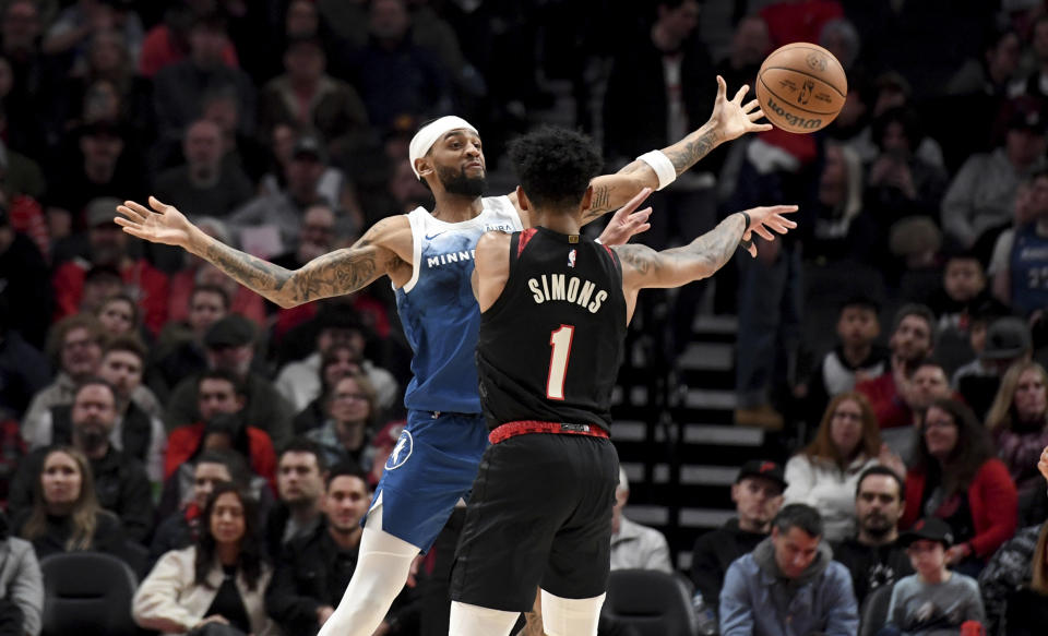 Portland Trail Blazers guard Anfernee Simons (1) passes the ball as Minnesota Timberwolves guard Nickeil Alexander-Walker defends during the first half of an NBA basketball game in Portland, Ore., Thursday Feb. 15, 2024. (AP Photo/Steve Dykes)