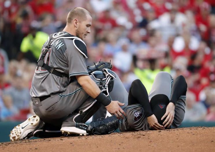 Arizona Diamondbacks starting pitcher Robbie Ray is checked on after being hit on the head by a line drive. (AP)