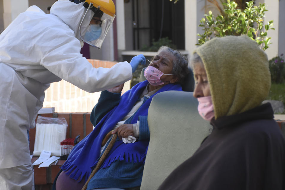 A health worker takes samples to test elderly residents for the new coronavirus at the San Jose nursing home in Cochabamba, Bolivia, Friday, July 17, 2020. At least 60 residents at the senior care facility tested positive for the new coronavirus and 10 have died with COVID-19 related symptoms in the last two weeks, amid a rise in cases and fatalities in the Andean country. (AP Photo/Dico Solis)