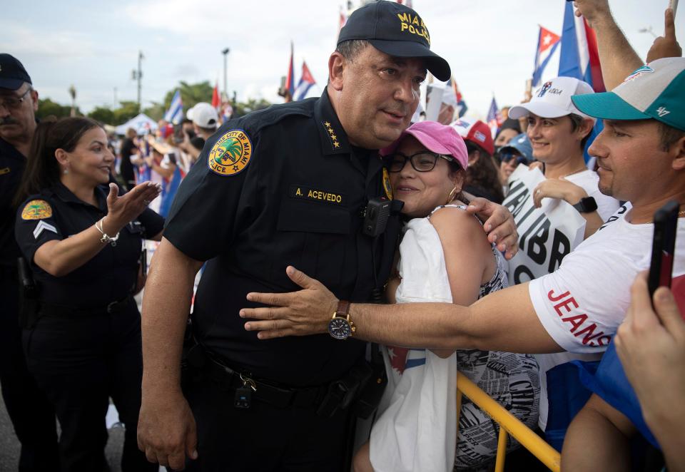 Former Miami Police Chief Art Acevedo hugs a protester in front of Versailles Restaurant in Miami.