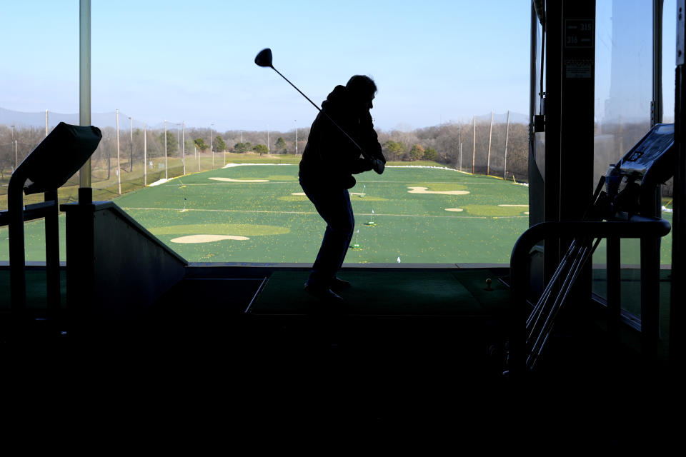 A golfer drives range balls on a warm day in Des Plaines, Ill., Feb. 1, 2024. On Feb.16, the University of Michigan released its preliminary reading of consumer sentiment for the month.
