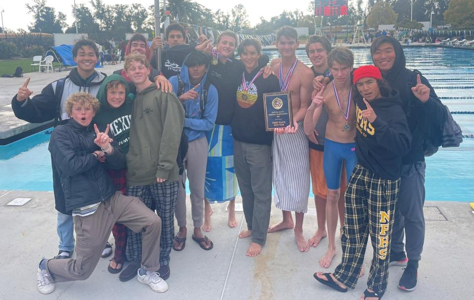 The Newbury Park High boys swimming team poses with the championship plaque after finishing first at the Ventura County Championships on Thursday at Buena High.